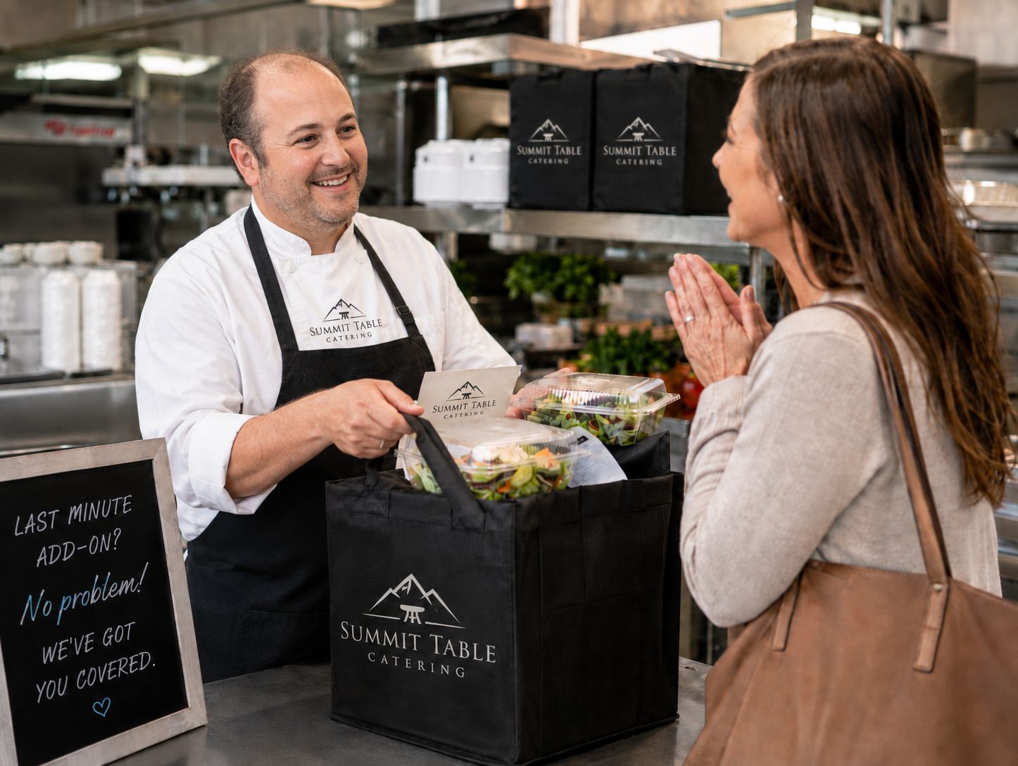 Chef handing a packed catering order to a customer